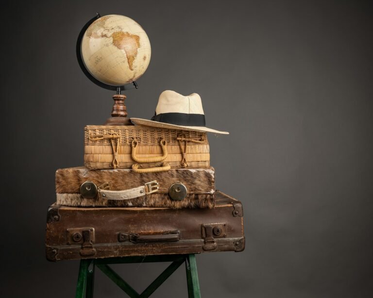 Closeup of vintage travel bags, a hat, and a world globe map on them - travel mood